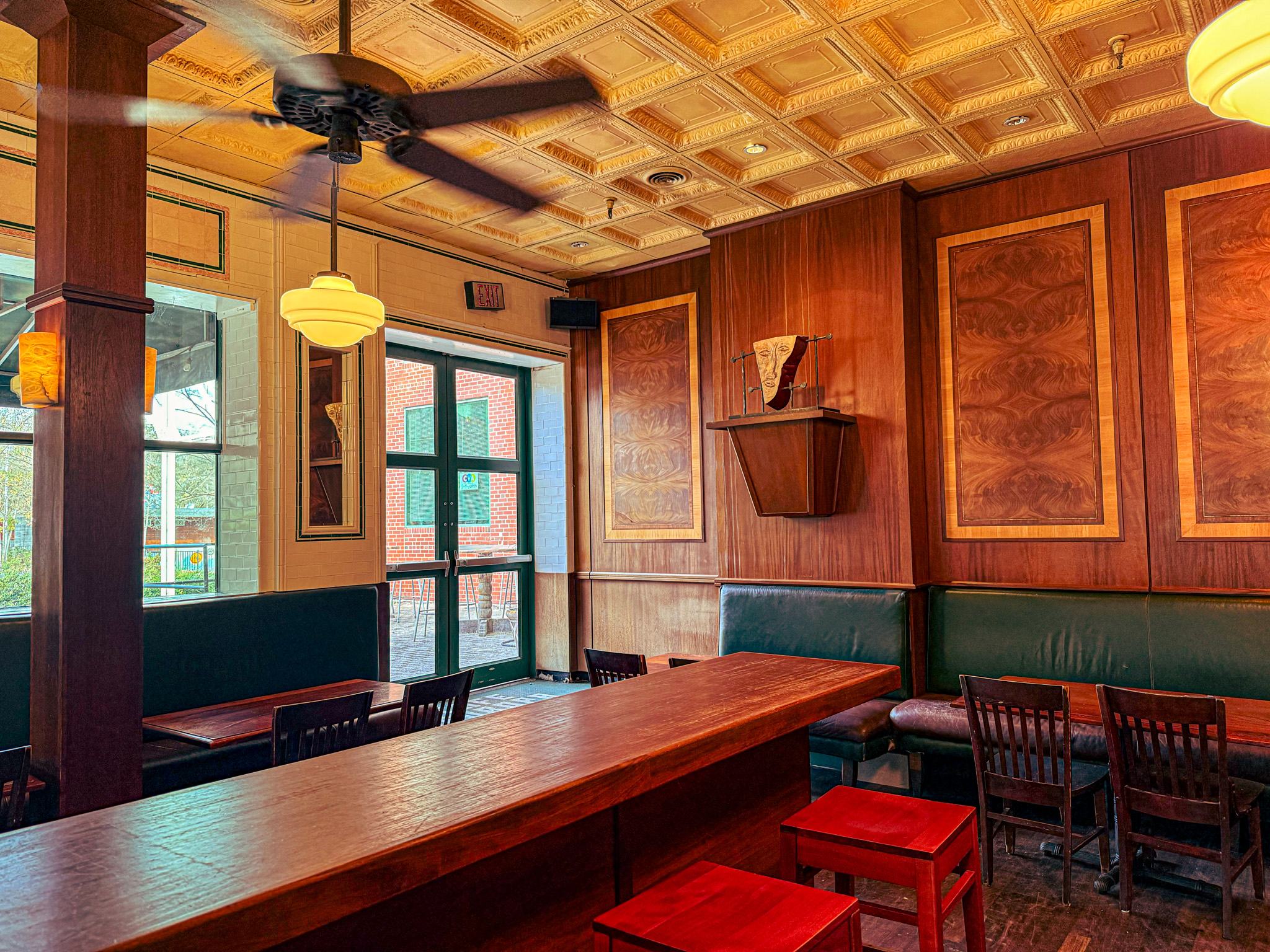 Interior of Europa Bar & Café, showing the green banquettes, green entry doors, and pressed-tin ceiling